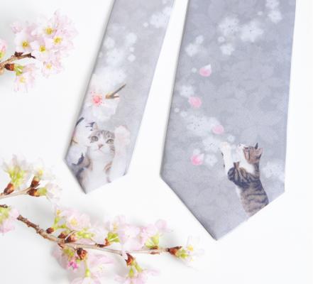 ネクタイのデザインは、桜の枝や花びらにじゃれている猫