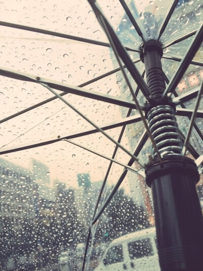 雨とビニール傘のイメージ写真