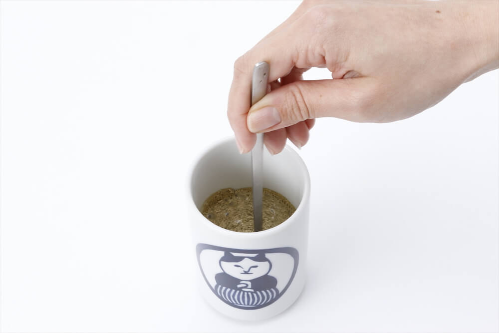  ねこ茶商印のほうじ茶ラテにお湯を注いでかき混ぜるイメージ