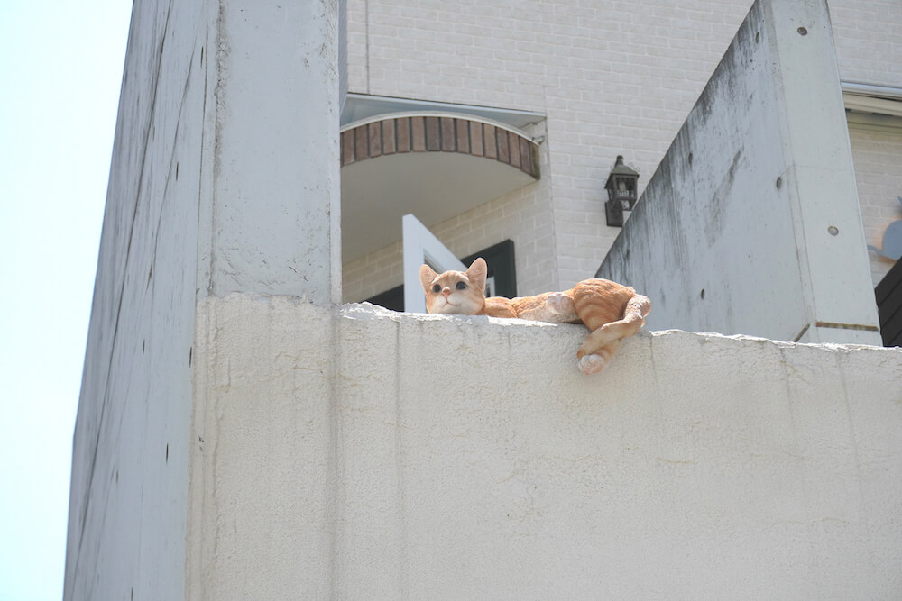 エントランスの壁の上にある猫のオブジェ by マイペリドットカフェ