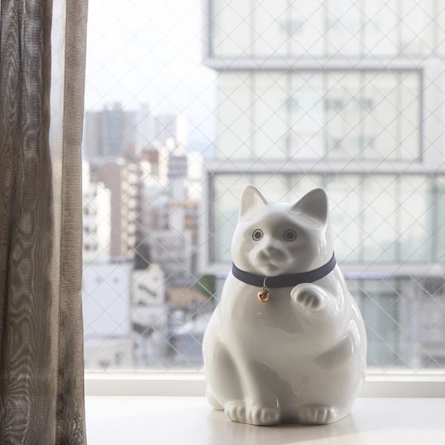 肥前吉田焼の招き猫型貯金箱（ホワイトカラー）を部屋に飾ったイメージ by KataKoto（カタコト）