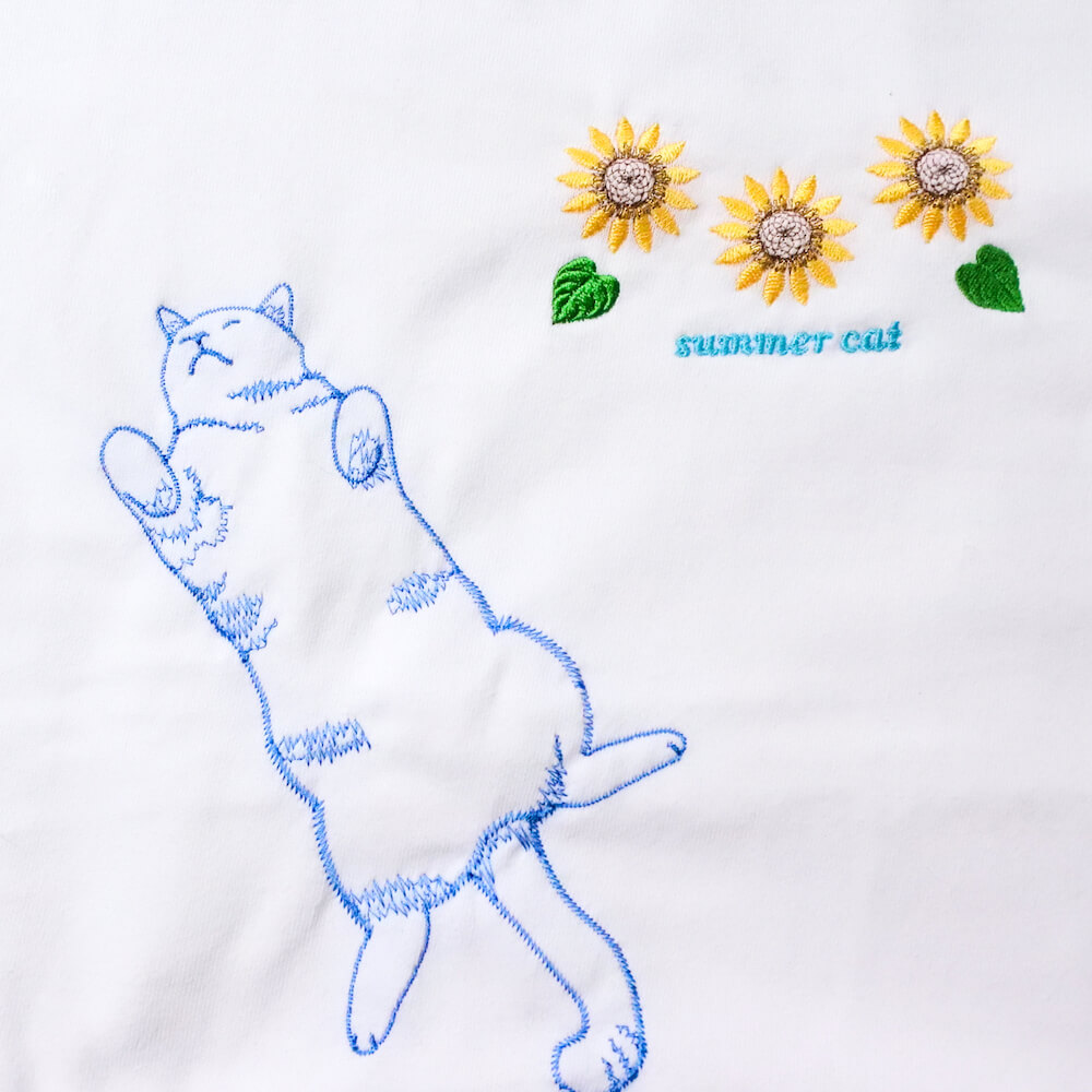 ひまわりとへそ天で寝る猫の刺繍Tシャツ by コイトネコ
