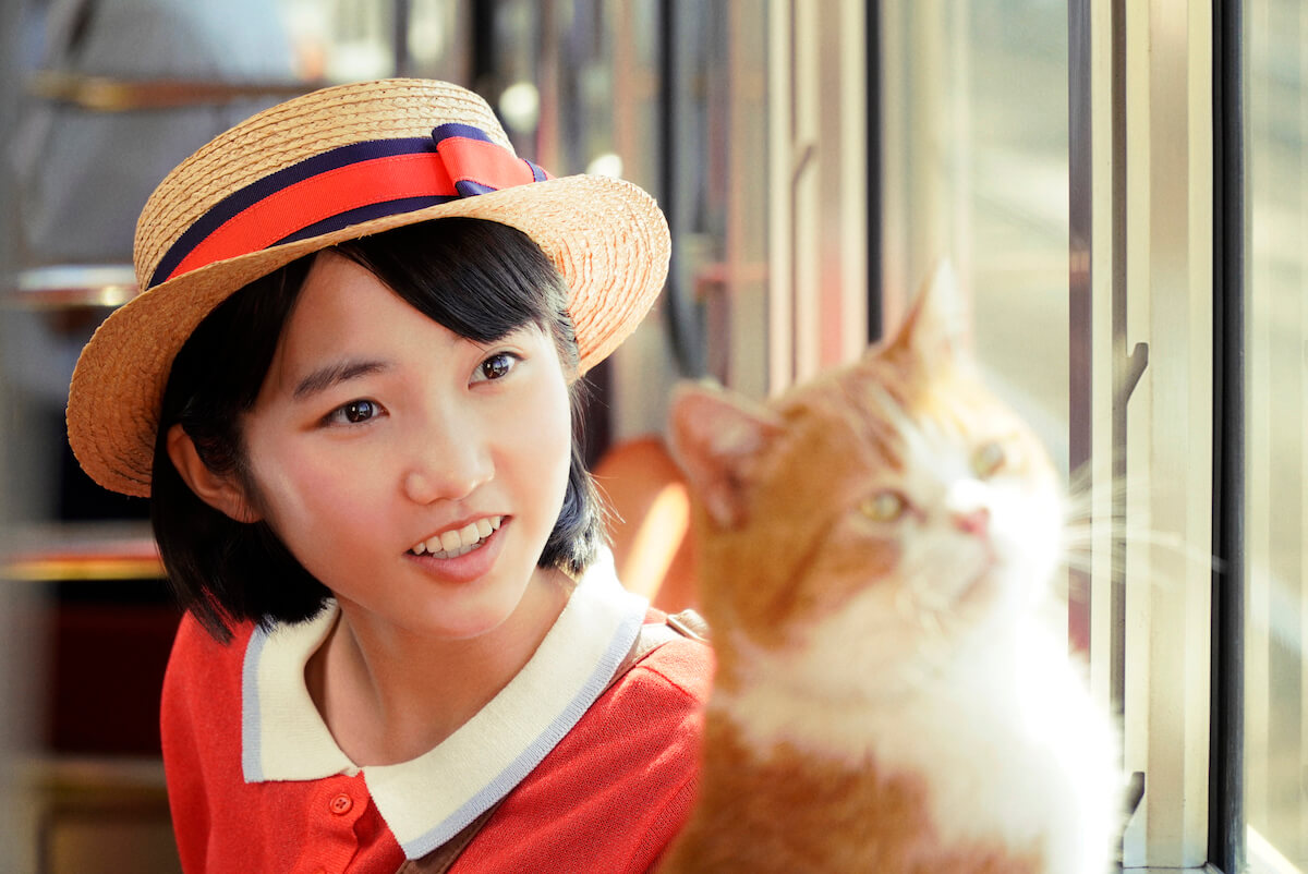 電車に乗る雫（安原琉那）と、猫のムーン（ぽんず） by 実写映画『耳をすませば』のワンシーン