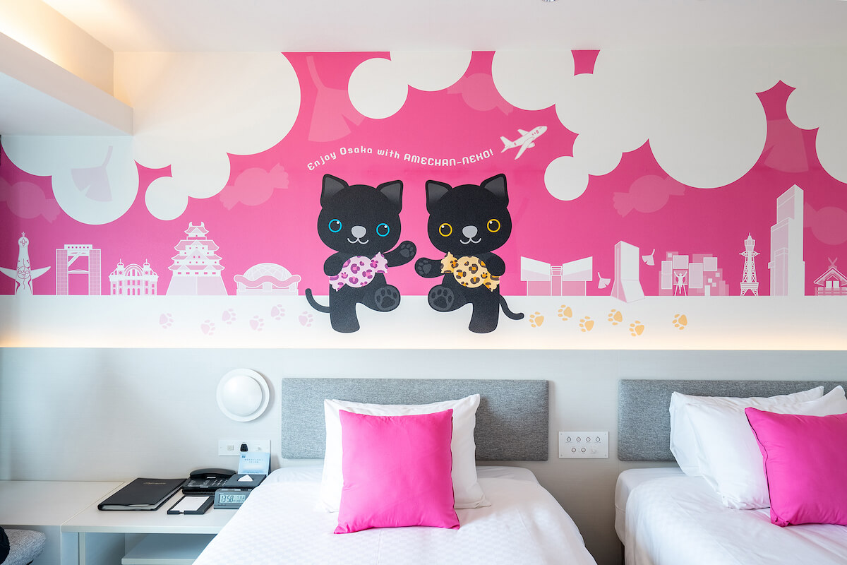 客室の壁に黒猫キャラクターの絵が装飾された「双子のアメちゃんねこ」 by ホテル日航大阪
