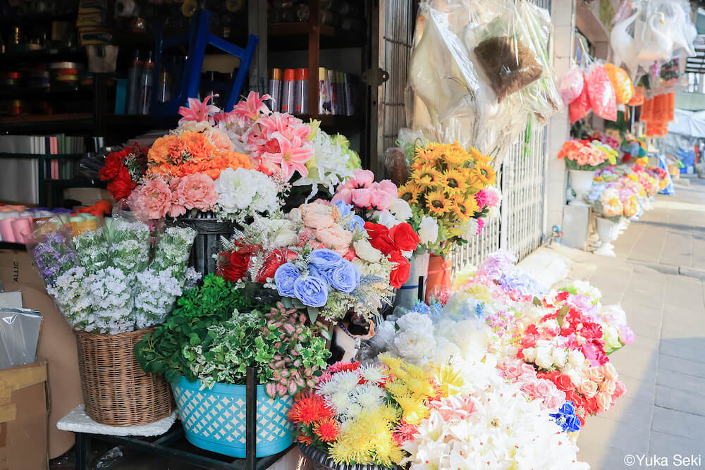 タイのお花屋さんで花に紛れる猫 by 関由香